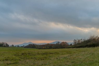 Skalky manzaralı çayır, sonbaharda karanlık bulutlu bir günde Labe nehrinin üzerindeki vadiyi gösteriyor.