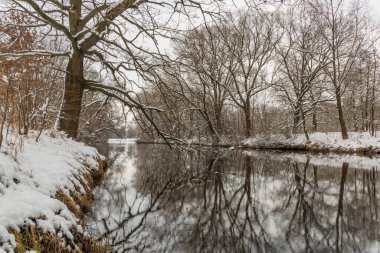 Malse nehri için kış manzarası ve karlı, bulutlu, gri bir günde Weir