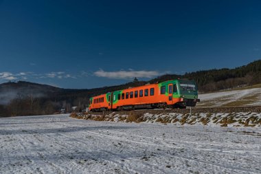 Güney Bohemya 'da güneşli bir günde Zlata Koruna istasyonu yakınlarında yolcu renk treni