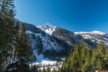 Avusturya Alplerinde soğuk güneşli ve güzel bir günde Riesachsee yakınlarında karlı bir yol.