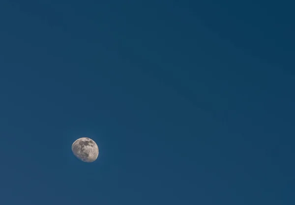 春の日当たりの良い日の夜にクルコノス島の山々に暗い青空と白い月 — ストック写真