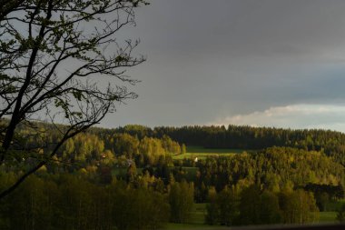 Gün batımında Bernov köyü üzerinde gökkuşağı yeşil taze çayırlar ile