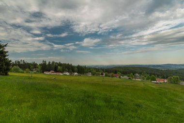 İlkbahar akşamı Javornik tepesi yakınlarındaki çayırlar ve ormanlar ve Sumava ulusal parkındaki köy.