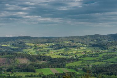 İlkbahar akşamı Javornik tepesi yakınlarındaki çayırlar ve ormanlar ve Sumava ulusal parkındaki köy.