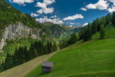 Grossarler ile yaz vadisi Ache küçük nehir ve mavi beyaz bulutlu gökyüzü