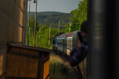Güneşin doğduğu sabah renk saatinde Plzen kasabası yakınlarındaki mavi czech trenleri
