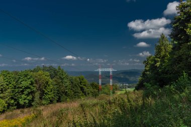 Ceske Stredohori 'de yeşil ormanları ve tepeleri olan yüksek voltaj renk kutupları