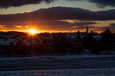 Karlı buzlu tarlaları ve Jindrichuv Hradec Hradec CZ 01 03 2025 evleriyle gün batımı