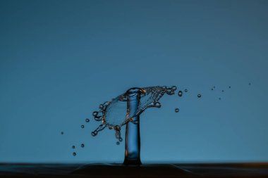 Temiz suya şemsiyeyle veya toplarla renk damlaları düşer