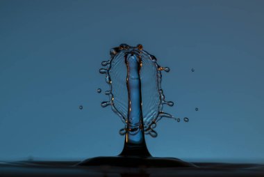 Temiz suya şemsiyeyle veya toplarla renk damlaları düşer