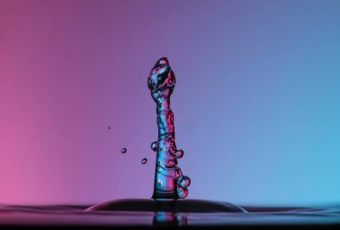 Temiz suya şemsiyeyle veya toplarla renk damlaları düşer