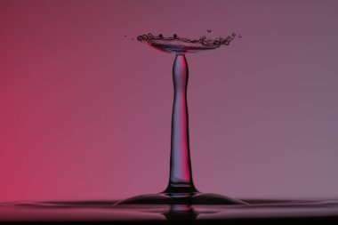 Temiz suya şemsiyeyle veya toplarla renk damlaları düşer