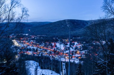 Krkonose 'daki büyük dağlarda akşam üstü buzlu mavi gökyüzü ile kayak pisti Harrachov CZ 02 20 2026