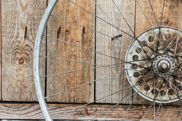 Vieille roue d'un vélo sur un fond en bois — Photo