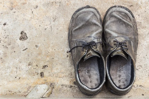 Le vecchie scarpe in vera pelle su sfondo di cemento — Foto Stock