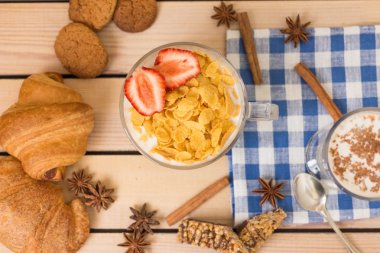 Mısır gevreği süt kruvasan ve ahşap arka plan günü kahvaltıda çilek ile