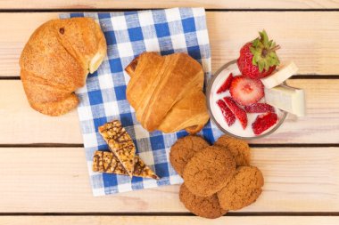 milkshake çilek ve yaban mersini, ahşap arka plan üzerinde pişmiş kruvasan ile