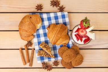 milkshake çilek ve yaban mersini, ahşap arka plan üzerinde pişmiş kruvasan ile