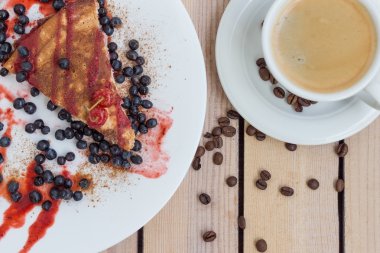 yaban mersini ve ahşap arka plan üzerinde kahve ile vişneli tart