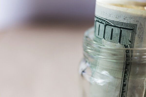 доллары в стеклянную банку. мелкая глубина резкости
