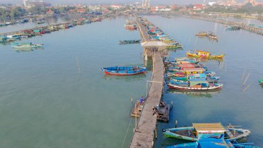 Gresik, Doğu Cava 'da renkli balıkçı teknelerinin bulunduğu uzun ve ahşap bir iskelenin havadan görünüşü kıyı yaşamını gözler önüne seriyor..