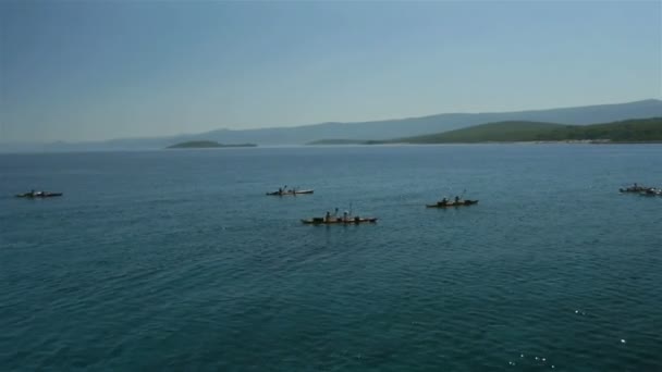 Воздушная группа гребцов на каяках к берегу моря — стоковое видео