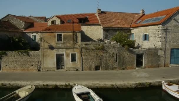 Velha casa de pesca e barcos atracados no canal Vrboska — Vídeo de Stock