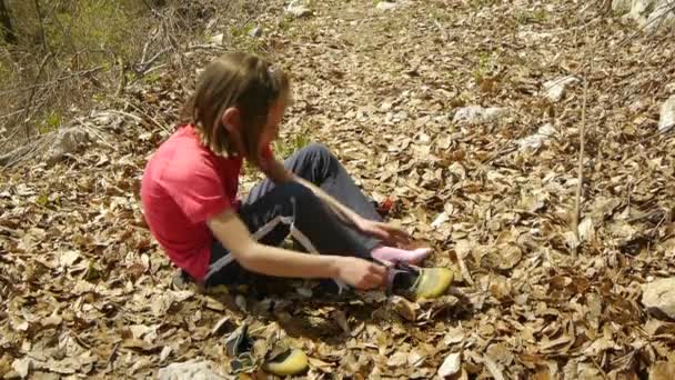 Девочка-подросток надевает туфли для скалолазания — стоковое видео