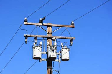 Dağıtım trafoları ve elektrik hatları olan bir elektrik direği