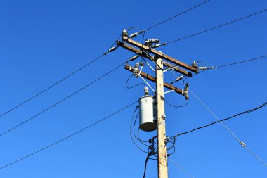 Dağıtım trafoları ve elektrik hatları olan bir elektrik direği