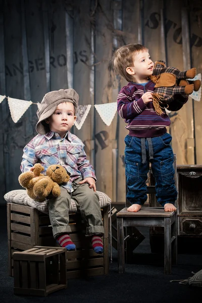 Dwóch chłopców w czapki siedzi na polach w studio około tak — Zdjęcie stockowe