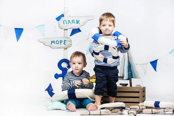 Two little boys in striped dress as sailors , lifebuoys , white — Stock Photo, Image