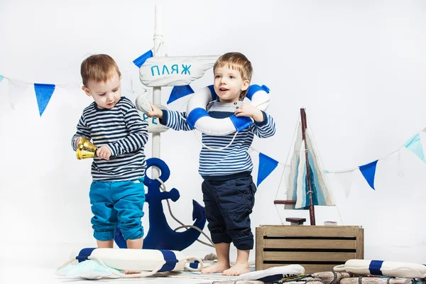 Dwóch chłopców w paski sukienkę jak żeglarzy, koła ratunkowe, biały — Zdjęcie stockowe