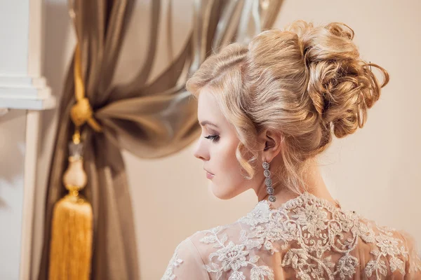 Beautiful portrait of a woman with blonde hair with an evening make-up .