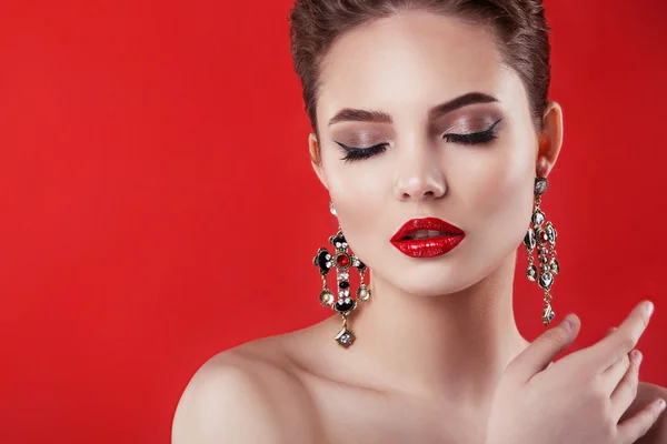 Hermosa modelo chica sobre un fondo rojo. La belleza de una mujer — Foto de Stock