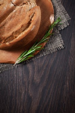 beyaz bir meme ve biberiye bir kesme tahtası üzerinde ev yapımı tereyağı ile ahşap bir arka plan üzerinde tereyağı ile taze ekmek