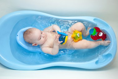 küçük bir çocuk mavi bir banyo oyuncakları yıkanmış .
