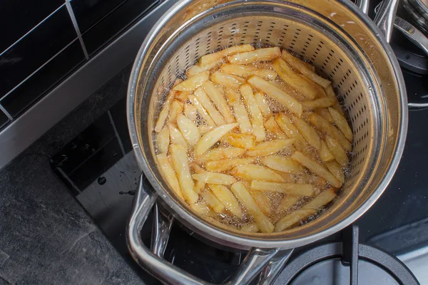 Spousta lahodných hranolků, vařené doma v horkém tuku v hlubokém frjeronu — Stock fotografie