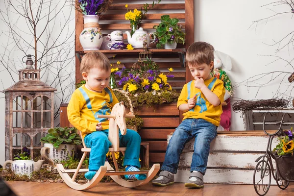 Діти на тлі весняного декору в жовтих футболках, квітковий луг  . — стокове фото