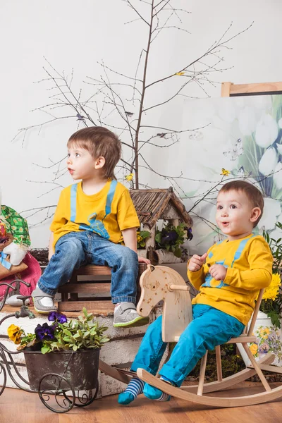 Children on the background of spring decor in yellow T-shirts , flower meadow . — Stock Photo, Image
