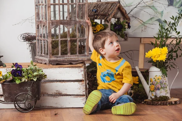 Anak-anak dengan latar belakang dekorasi musim semi dengan kaos kuning, padang rumput bunga  . — Stok Foto