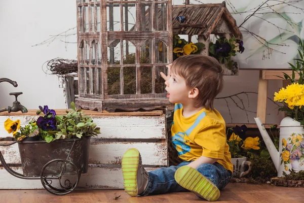 Children on the background of spring decor in yellow T-shirts , flower meadow . — Stock Photo, Image