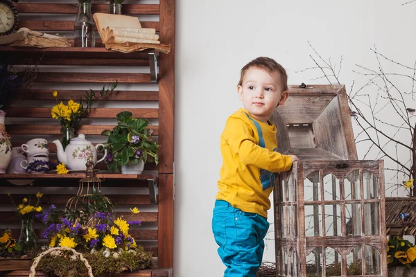 Anak-anak dengan latar belakang dekorasi musim semi dengan kaos kuning, padang rumput bunga  . — Stok Foto