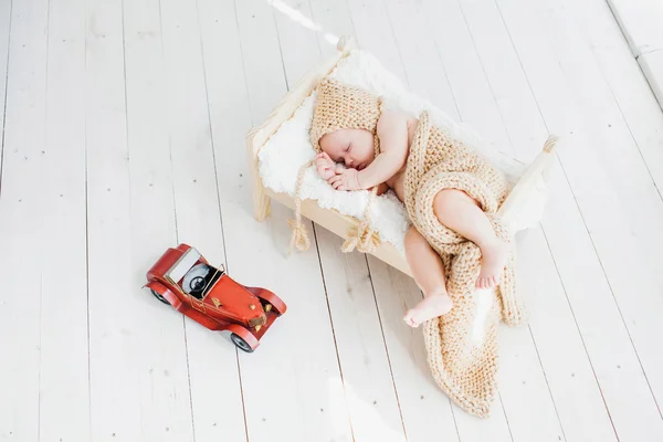 Una familia joven con un pequeño bebé agradable y dulce sentado en el sofá en un interior brillante — Foto de Stock