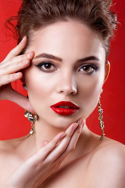 Menina modelo bonita em um fundo vermelho. A beleza de uma mulher — Fotografia de Stock