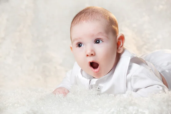 Neugeborenes Baby in einem schönen weißen Kleid auf hellem Hintergrund, Porträt . — Stockfoto