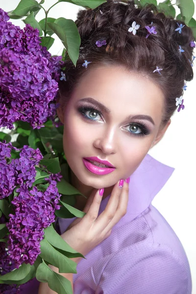 Mujer joven con flores lila — Foto de Stock