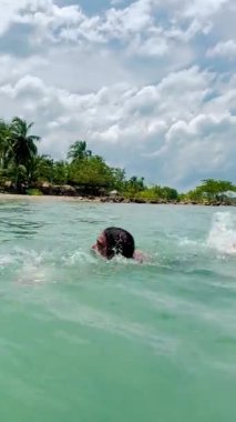 Kolombiyalı uzun saçlı ve sakallı bir adam gün boyunca Coveas 'ın berrak sularında yüzüyor.