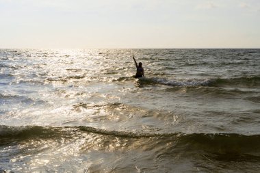 Karayipli kadın Covenhas 'ta gökyüzünü işaret ediyor. Denize batmış, altın ışıkla çevrili ve tropik bölgelerde fotokopi çekiliyor.