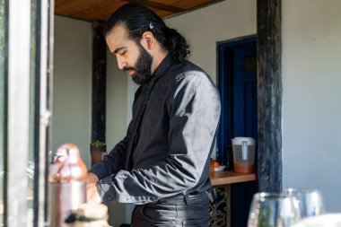 Barmen sıcak ışıkla kırsal otel barında cam kenarında içki hazırlıyor.